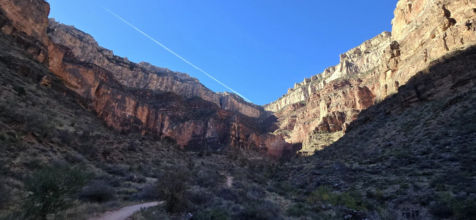 A sunlit trail winding through the walls of the Grand Canyon