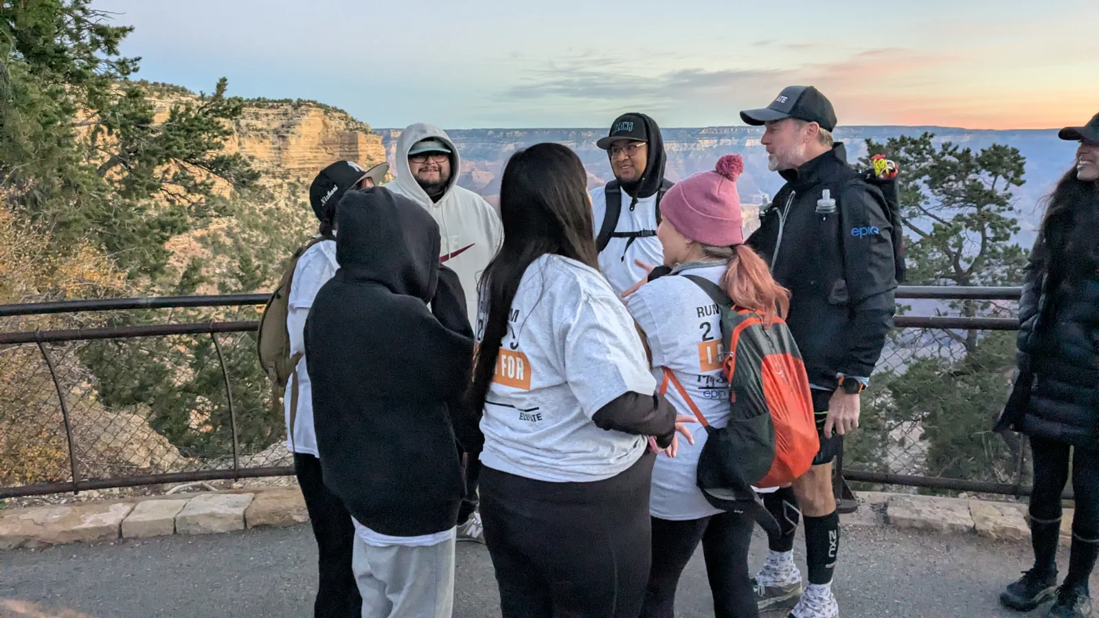 The 2025 Run the Rim team gathering at a canyon overlook at sunrise